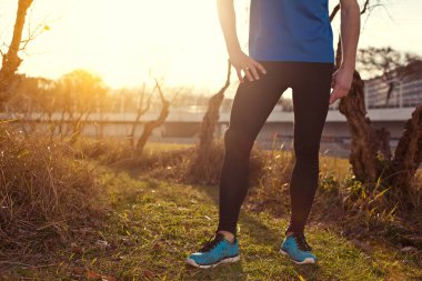 Erkek atlet (kasıtlı güneş parlamayı gün batımında parkta duran)