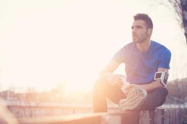 Şişe su, armba ile parkta bankta oturan atlet