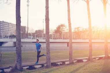Parkta günbatımında çalışan atlet (küçük Hareket Bulanıklığı, sonraorada