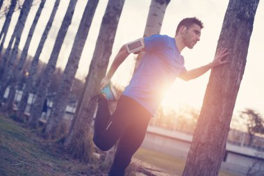 Güneş Park'ta çalıştırmak için germe kasları yapıyor atlet