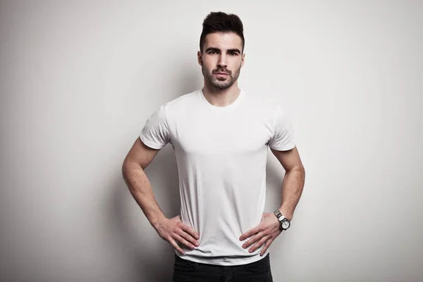 Serious young man in white blank t-shirt — Stock Photo, Image