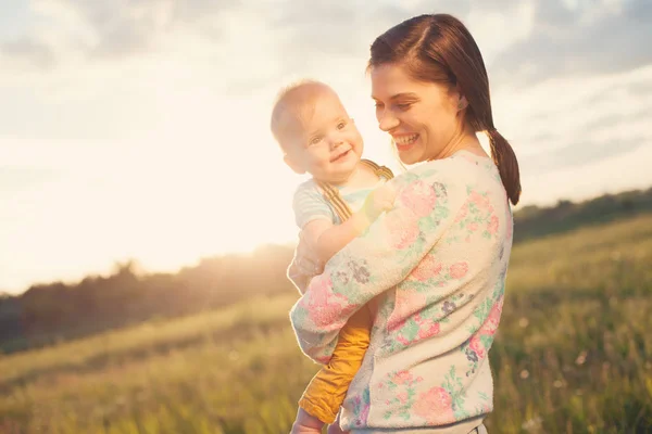 Mutlu ve gülümseyerek anne ile bebeği parkta vakit