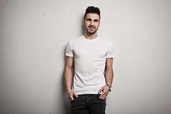 Junger Mann in leerem T-Shirt, weißer Grunge-Hintergrund Stockfoto