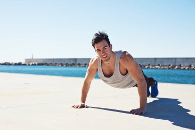 Gülümseyen atlet açık havada yukarı itin yaparken uygun