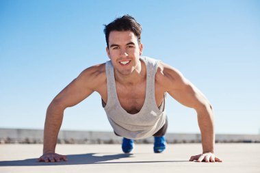 Atlet açık havada yukarı itin yapıyor