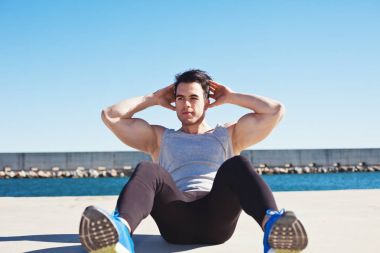 Yakışıklı atlet açık havada karın spor egzersizleri yapıyor