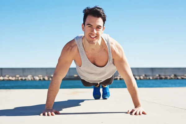 Bello atleta in forma facendo spingere all'aperto — Foto Stock