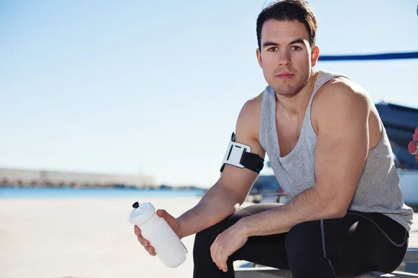 Porträt eines fitten männlichen Athleten mit Wasserflasche — Stockfoto