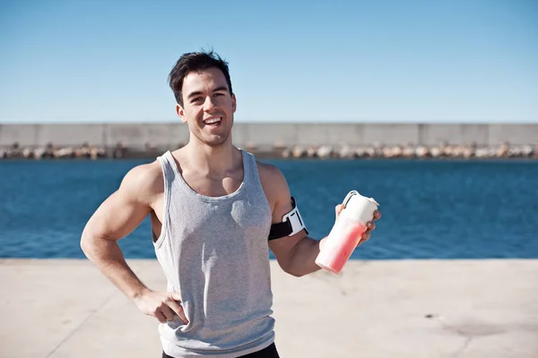 Guapo atleta sonriente con cóctel de proteínas —  Fotos de Stock