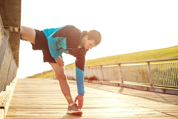 parkta uzanan ve kulaklık müzik dinleme sporcu
