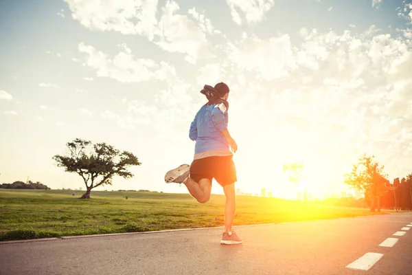 Sportman uitvoeren in het park in de zonsondergang — Stockfoto