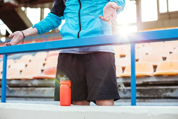 Empörter Sportler mit Wasserflasche steht am Geländer — Stockfoto