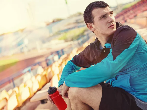 kırmızı spor şişe su ile yorgun sporcu