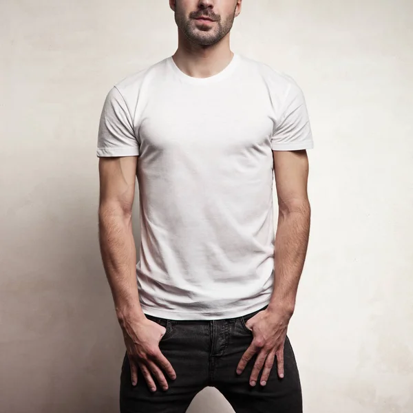 Camiseta blanca en blanco sobre hermoso hombre atlético, frente y fondo de hormigón —  Fotos de Stock