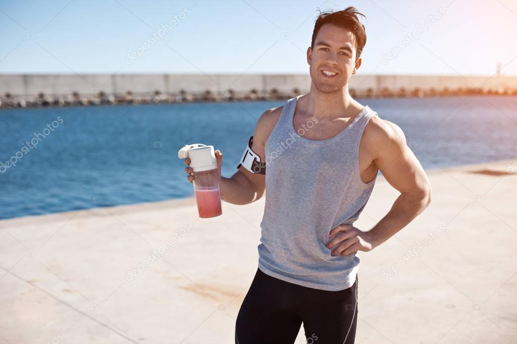 Smiling athlete with protein cocktail