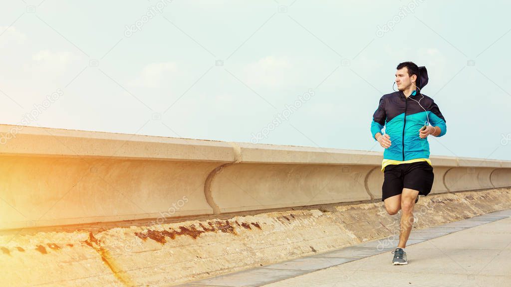 sportsman running near concrete fencing and looking far away
