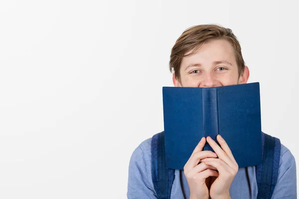 Menino Adolescente Feliz Sorrindo Cobrindo Metade Rosto Com Livro Azul — Fotografia de Stock