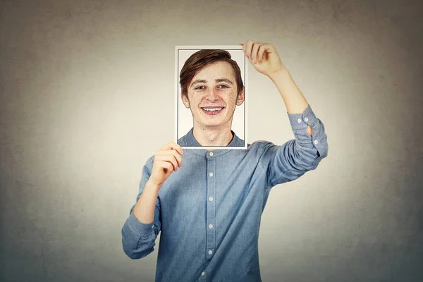 Adolescente niño cubriendo la cara usando un papel foto impresión con uno mismo po — Foto de Stock