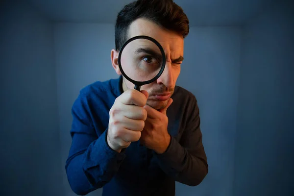 Surprised Young man student holding magnifying glass looking to — Stock Photo, Image