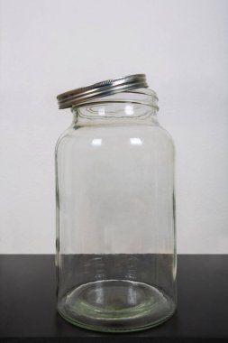 Boş bir kavanozun fotoğrafını çek, masanın üstünde, metal bir kapakla.