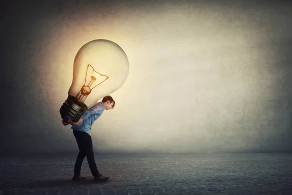 Un geniale studente che porta una grossa lampadina sulla schiena. Ove — Foto Stock