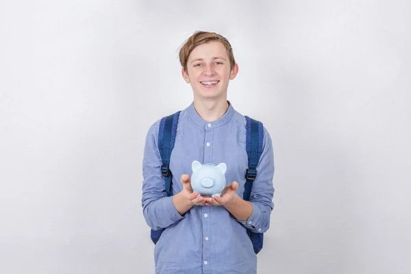 Χαμογελώντας έφηβος αγόρι κρατώντας κουμπαρά πάνω από λευκό φόντο. Φ — Φωτογραφία Αρχείου