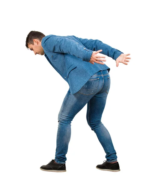 Bent down young man keeps hands back as carrying an heavy invisi — Stock Photo, Image