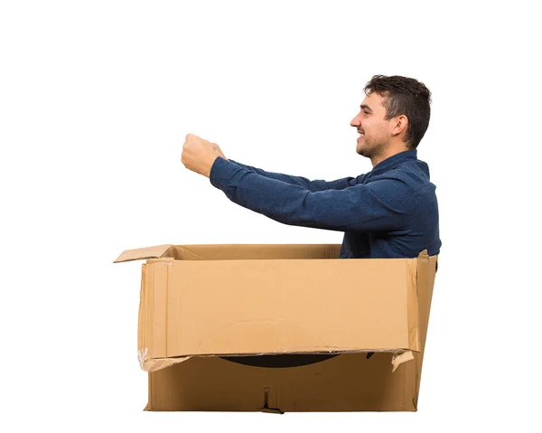 Full length side view of childish man sitting inside a cardboard — Stock Photo, Image