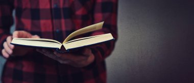 Close up of reader hands holding an open book finding informatio