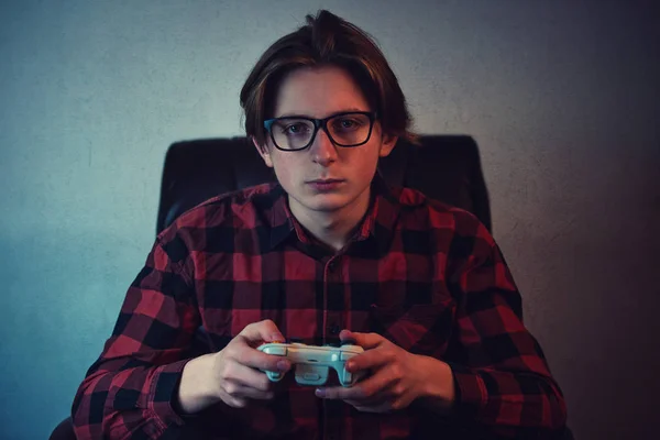 Серйозний підліток хлопчик грає у відеоігри пізно ввечері сидить у — стокове фото