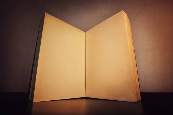 Sluit een open boek, op tafel, met gouden blanco pagina 's. Oud — Stockfoto