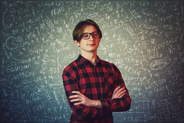 Умный студент-ботаник в очках уверенно стоит, держит руки скрещенными, решая сложные математические расчёты и уравнения. Озадаченный парень знает экономическую формулу, имеет новую концепцию проектных идей
.