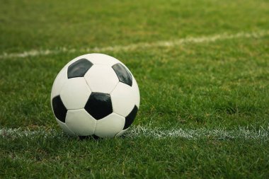 Klasik futbol topu, tipik siyah-beyaz desenli, stadyum sahasının beyaz çizgisi üzerine yerleştirilmiş. Yeşil çimlerin üzerinde fotokopi alanı olan geleneksel futbol topu.