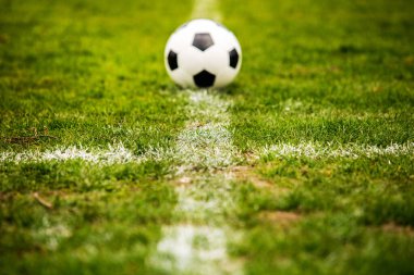 Klasik futbol topu, tipik siyah-beyaz desenli, stadyum sahasının beyaz çizgisi üzerine yerleştirilmiş. Yeşil çimlerin üzerinde fotokopi alanı olan geleneksel futbol topu.