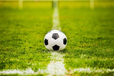Klasik futbol topu, tipik siyah-beyaz desenli, stadyum sahasının beyaz çizgisi üzerine yerleştirilmiş. Yeşil çimlerin üzerinde fotokopi alanı olan geleneksel futbol topu.