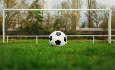 Stadyum kapısının önündeki serbest atış çizgisinde tipik bir futbol topu. Kaleden önce yeşil çimlerde geleneksel futbol topu.