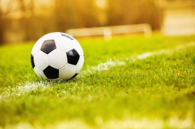 Klasik futbol topu, tipik siyah-beyaz desenli, stadyum sahasının beyaz çizgisi üzerine yerleştirilmiş. Yeşil çimlerin üzerinde fotokopi alanı olan geleneksel futbol topu.