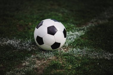 Klasik futbol topu, tipik siyah-beyaz desenli, stadyum sahasına yerleştirilmiş. Yeşil çimlerin üzerinde fotokopi alanı olan geleneksel futbol topu.