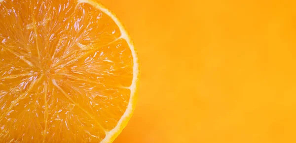 Orange fruit slice isolated on yellow background. Close-up of  fresh orange slice over orange background. Bio and healthy food.