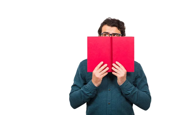 Estudante Escondido Atrás Livro Vermelho Olhando Para Lado Suspeito Isolado — Fotografia de Stock