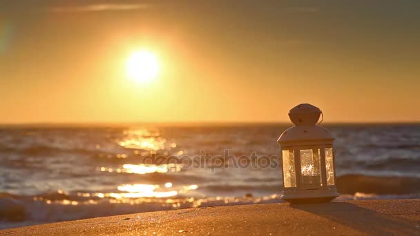 Lanterna branca na praia ao pôr do sol — Vídeo de Stock