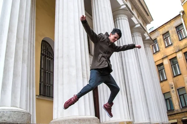 Happy man jumping with cityscape in the background