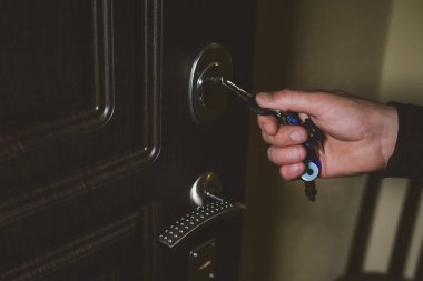 Erkek el anahtarın anahtar deliği içinde koyar.