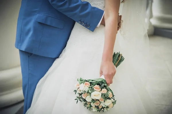 Свадьба. Жених держит невесту на руках. Невеста в объятиях прекрасного свадебного букета — стоковое фото