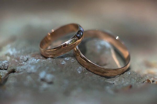 two golden wedding rings on the stone, wedding rings background concept