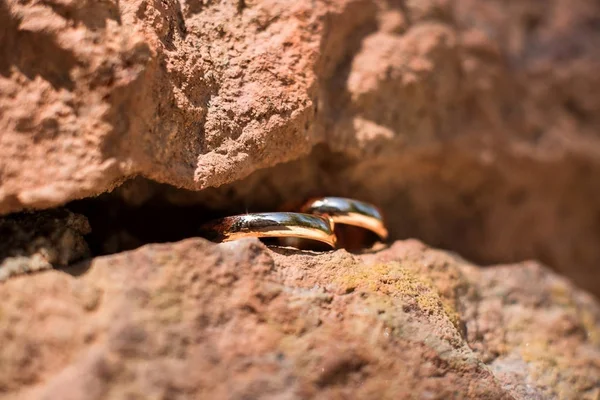 Dos anillos de boda de oro en la hendidura de la roca, anillos de boda concepto de fondo — Foto de Stock