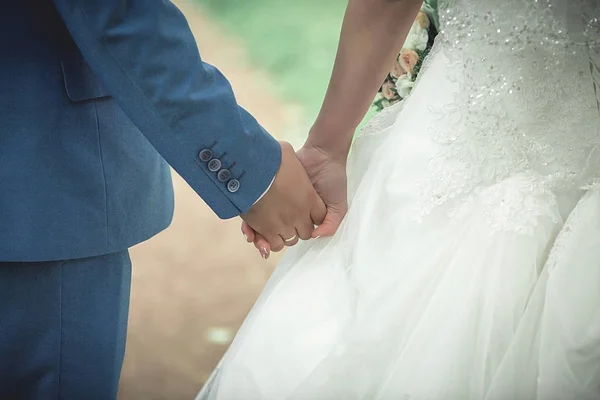 Jovem casal de mãos dadas, dia do casamento cerimônia — Fotografia de Stock