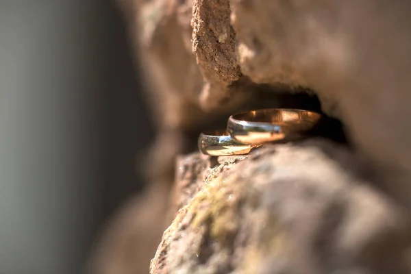Dois anéis de casamento dourados na fenda da rocha, conceito de fundo anéis de casamento — Fotografia de Stock