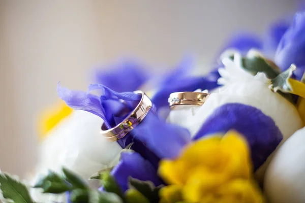 Two golden wedding rings on flowers, wedding rings background concept — Stock Photo, Image