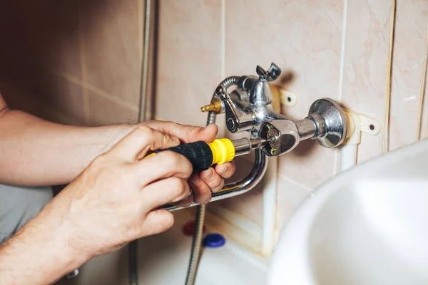 Uomo riparazione e fissaggio vecchio rubinetto che perde in bagno — Foto Stock